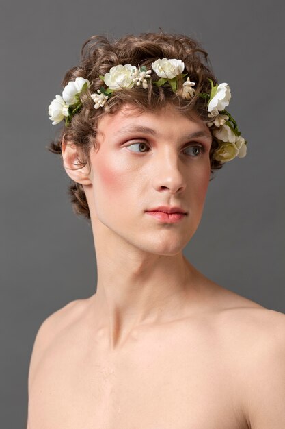 メイクと花の花輪を身に着けている肖像画の若い男