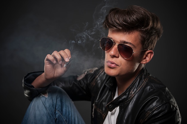 선글라스를 착용하고 흡연 젊은 남자의 초상화