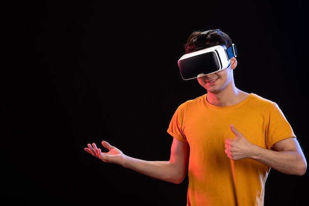 Portrait of young man wearing virtual reality headset dark  video gaming d