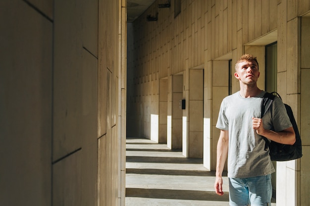 Portrait of young man with backpack looking away