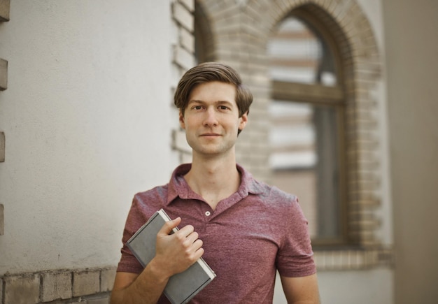 Free photo portrait of young man with a book in his hand