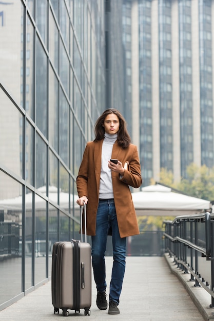 Free photo portrait of young man with luggage