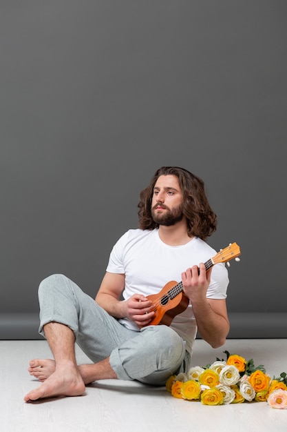 Free photo portrait young man with ukulele