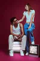 Foto gratuita ritratto di giovane uomo e donna in stile moda anni 2000 in posa con la tv