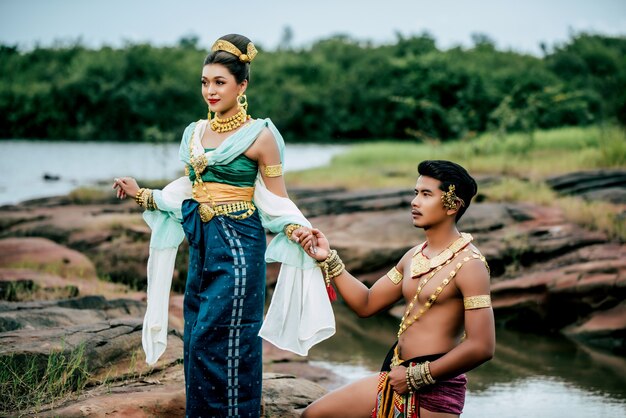 Portrait of Young man and woman wearing beautiful traditional costume pose in nature in Thailand
