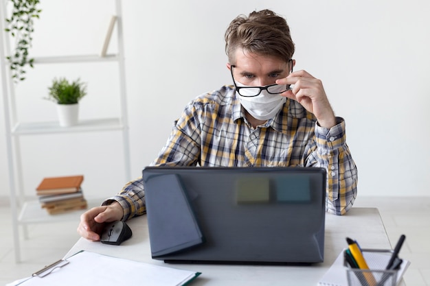 Free photo portrait of young man working from home