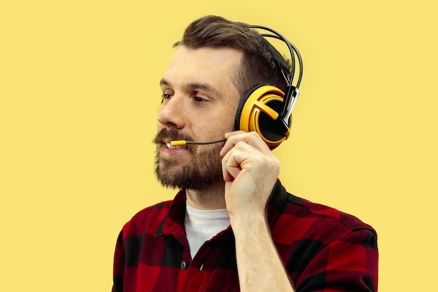 Portrait of young man on yellow wall.