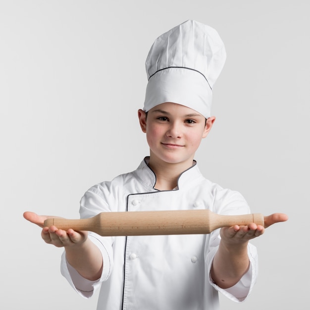Портрет молодого шеф-повара, держащего скалку