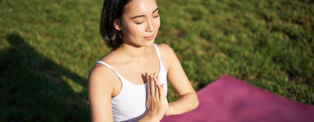 Free photo portrait of young mindful woman practice yoga exercising inhale and exhale on fresh air in park