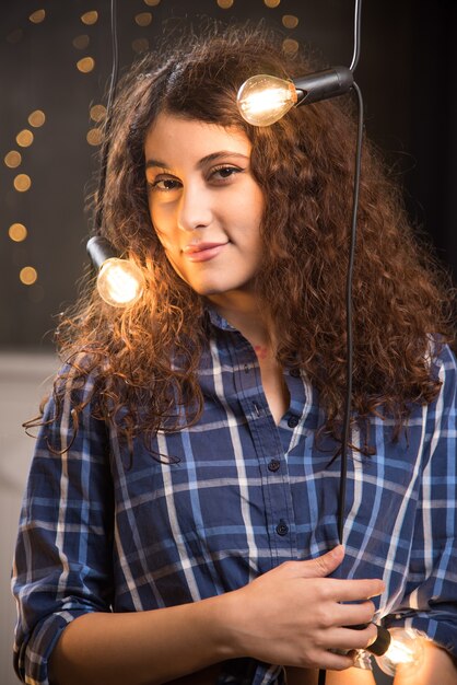 Portrait of a young model in plaid shirt posing near lamps