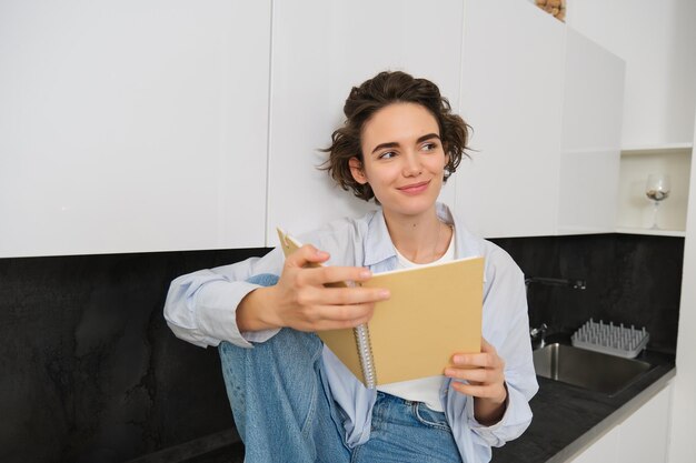 부에 앉아 일기를 읽고 행복하게 웃는 젊은 현대 여성의 초상화