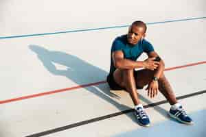 Free photo portrait of a young motivated african fitness man in earphones