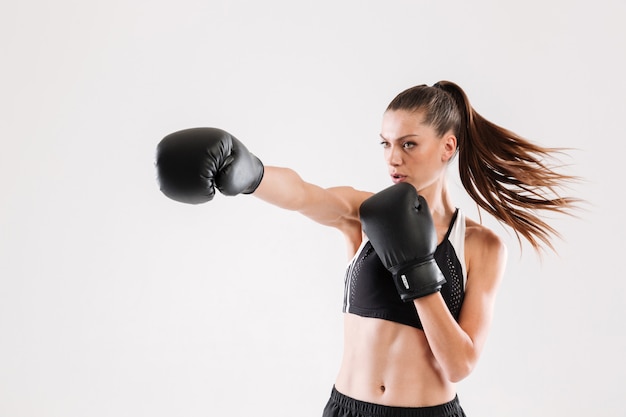 Портрет молодой мотивированной женщины делают бокс