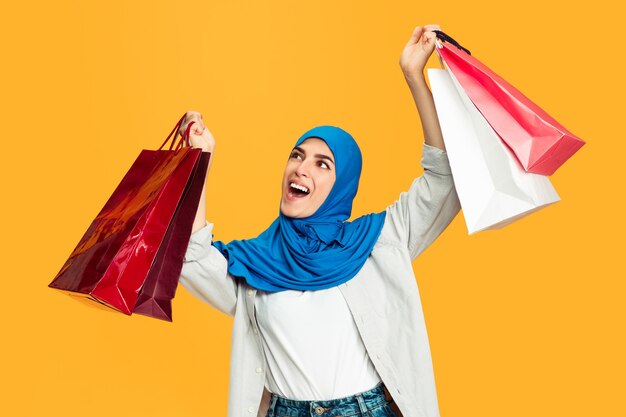 Portrait of young muslim woman isolated on yellow  wall