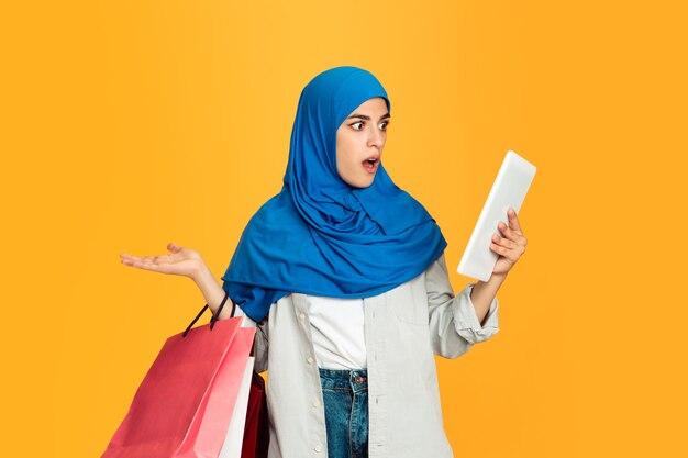 Portrait of young muslim woman on yellow