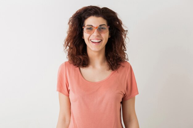 Portrait of young natural happy hipster pretty woman with curly hairstyle in pink shirt posing wearing glasses isolated, positive mood