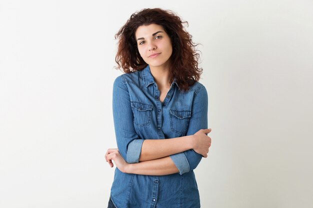 Portrait of young natural smiling pretty woman with curly hairstyle in denim shirt posing isolated