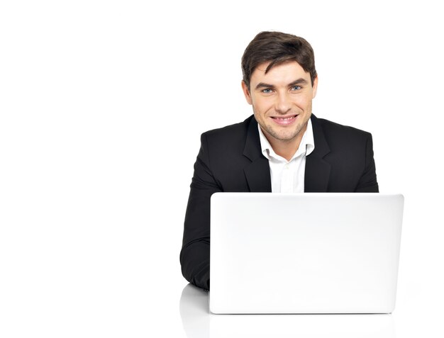 Portrait of young office worker with laptop sitting on table isolated on white.