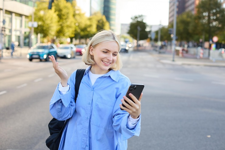 Free Photo portrait of young office worker woman walking along street chatting on the phone looking at