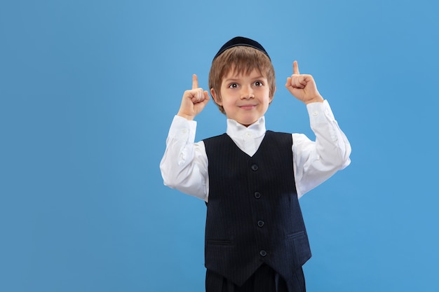 Portrait of a young orthodox jewish boy isolated on blue studio
