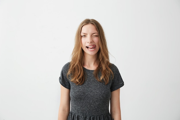 Free photo portrait of young positive pretty girl winking showing tongue .