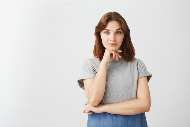 Portrait of young pretty beautiful girl posing with hand on chin .