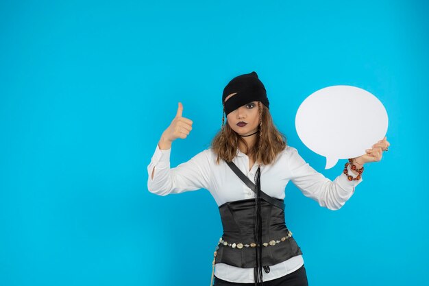 Portrait of young pretty pirate girl holding idea board and gesture thumb up. High quality photo