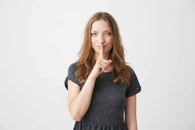 Free photo portrait of young pretty tender girl smiling straight showing keep silence .