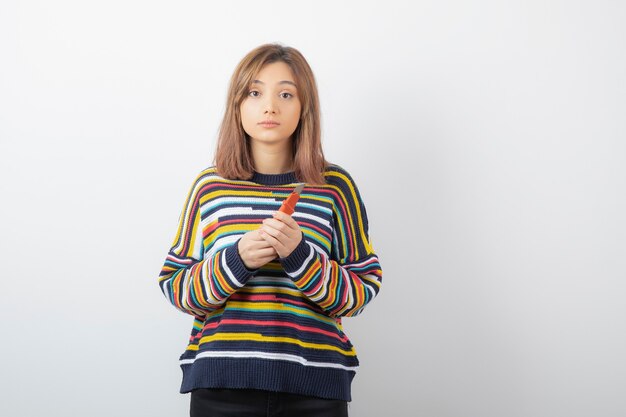 Portrait of a young pretty woman model standing and holding box cutter.