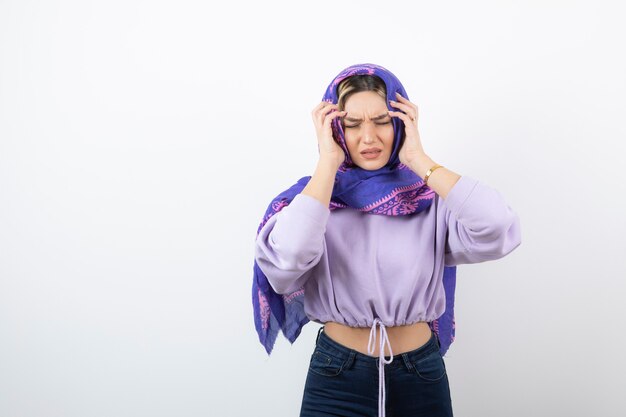 Portrait of a young pretty woman model standing and holding head.