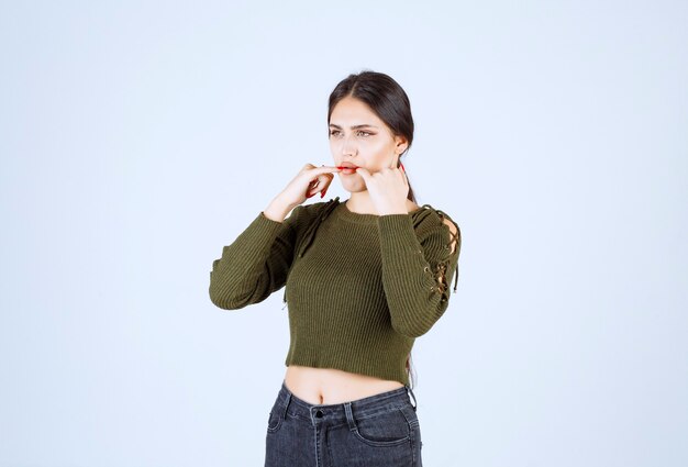 Portrait of a young pretty woman model whistling with her fingers.