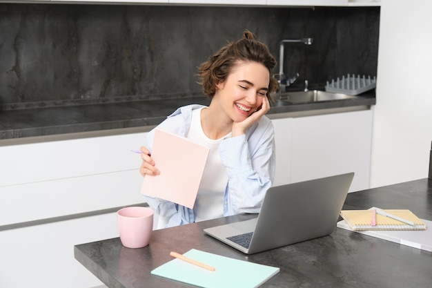 Free photo portrait of young professional woman works from home looks at laptop studies online connects to a