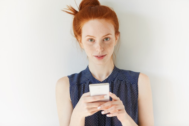 Free photo portrait of young red-haired woman holding phone