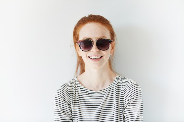 Portrait of young red-haired woman wearing sunglasses