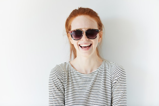 Portrait of young red-haired woman wearing sunglasses