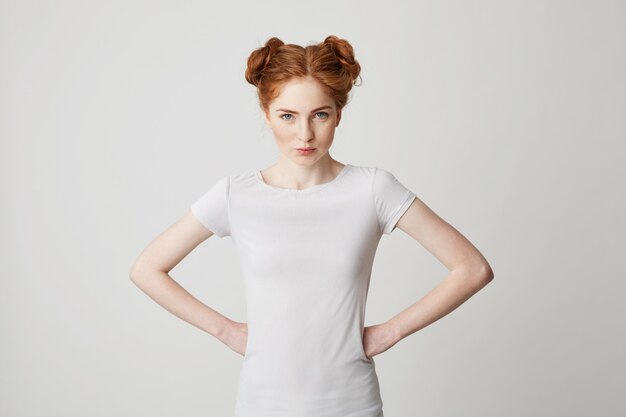 Portrait of young redhead girl straight with arms akimbo .