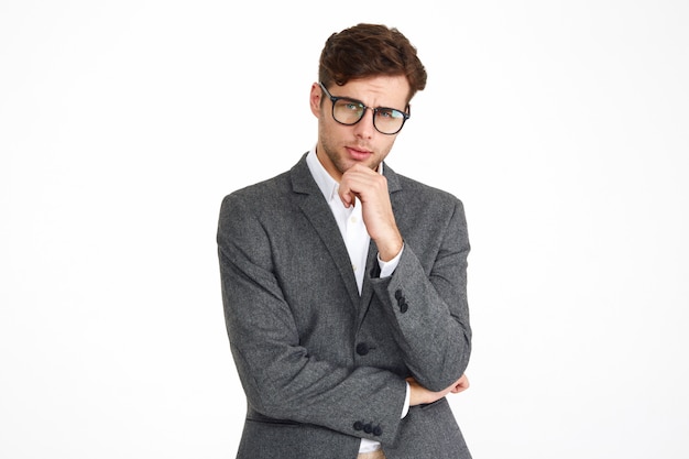 Portrait of a young serious business man in eyeglasses