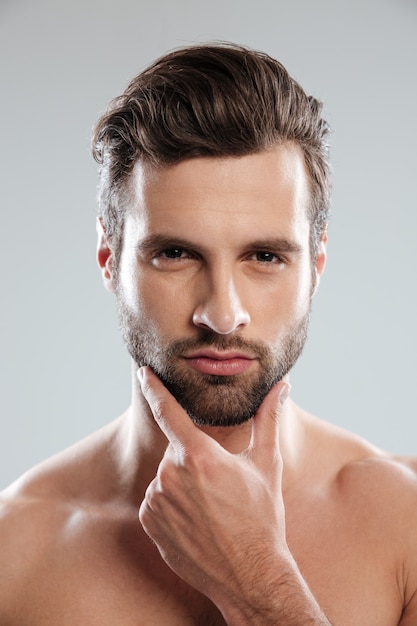 Portrait of a young sexy naked man touching his chin