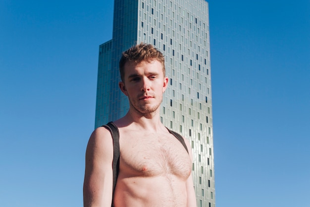 Portrait of young shirtless man looking at camera