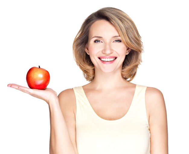 Portrait of a young smiling healthy woman with red apple isolated on white.