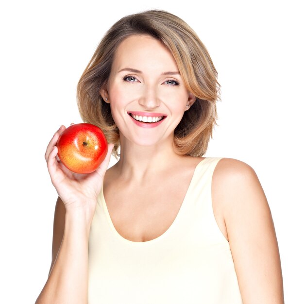 Портрет молодой улыбающейся здоровой женщины с красным яблоком, изолированным на белом.