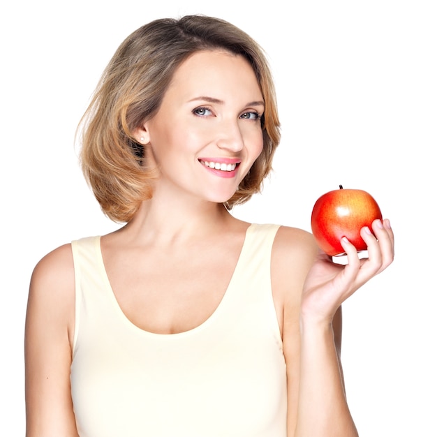 Портрет молодой улыбающейся здоровой женщины с красным яблоком - изолированным на белом.