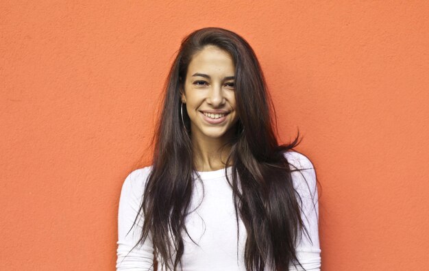 portrait of a young smiling woman on a red background