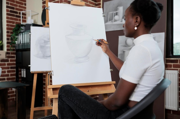 Portrait of young student enjoying art class developing painting skills for personal growth. Creative woman attending artistic lesson learning how to draw graphic illustration on canvas