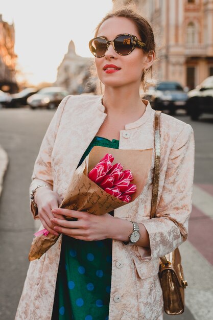 Portrait of young stylish attractive woman walking in city