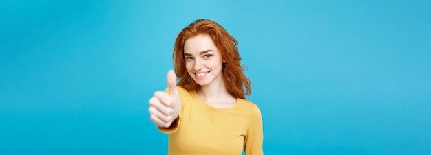 Free photo portrait of young stylish freckled girl laughing with showing thumps up at camera copy space