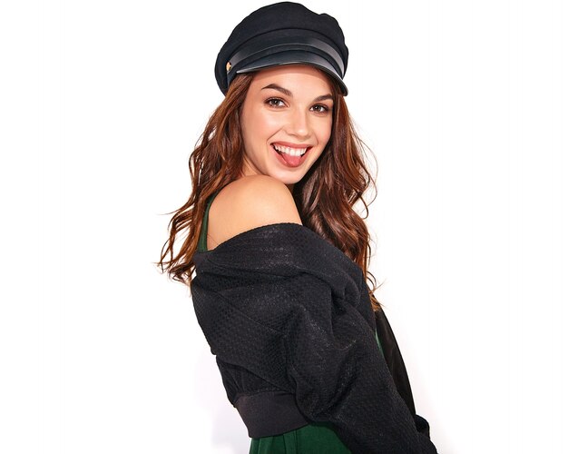 Портрет молодой стильной смеющейся модели в черной повседневной летней одежде в кепке с натуральным макияжем на белом