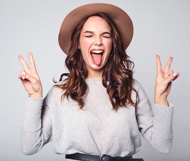 Portrait of young stylish laughing model in gray casual summer clothes in brown hat with natural makeup