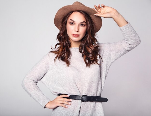 Portrait of young stylish laughing model in gray casual summer clothes in brown hat with natural makeup