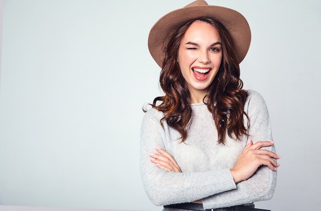 Portrait of young stylish laughing model in gray casual summer clothes in brown hat with natural makeup